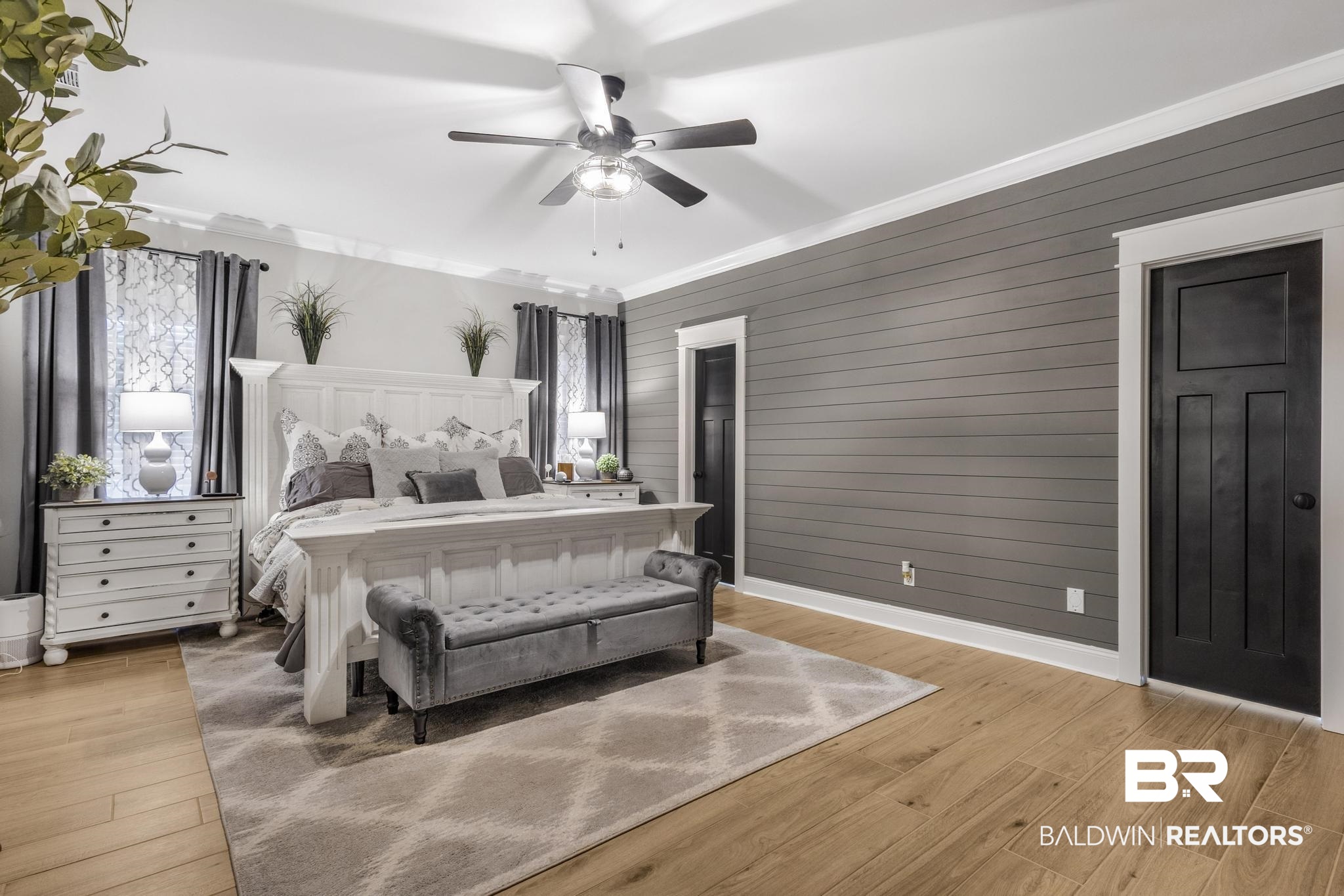 83 Caisson Trace Daphne, AL 36527 - Photo 33 of 63 Spacious room featuring wood-finish flooring, a shiplap accent wall, crown molding, and two panel doors with white trim