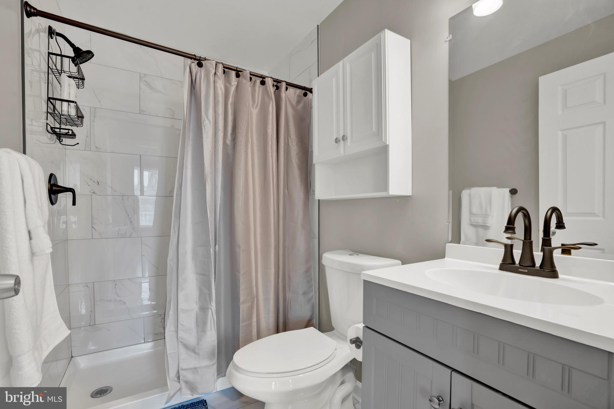 2111 East Chase Street Baltimore, MD 21213 - Photo 15 of 19 a bathroom with a sink a toilet and shower