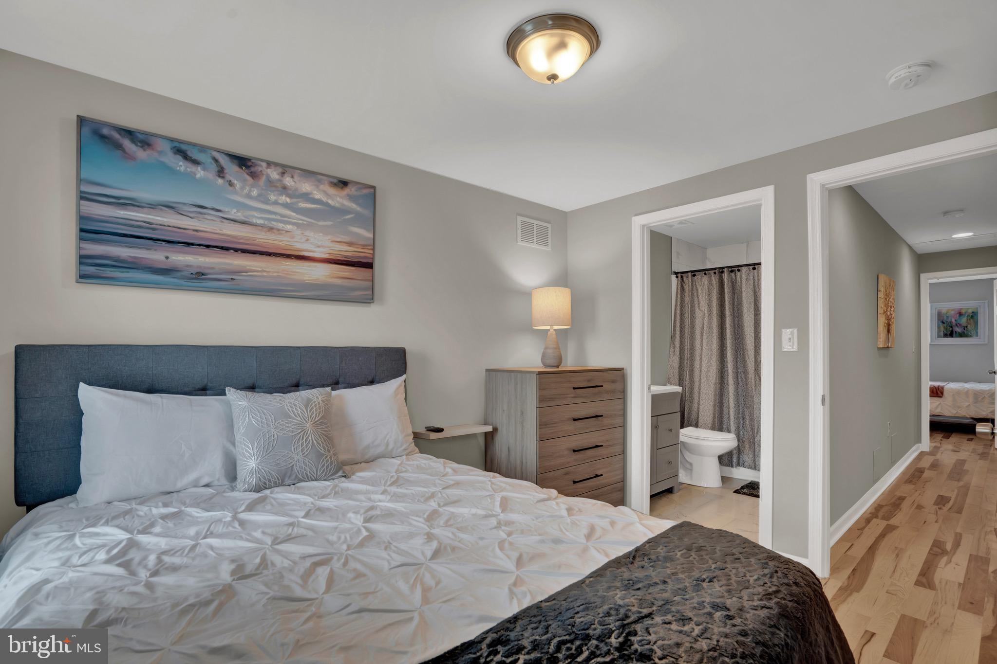 2111 East Chase Street Baltimore, MD 21213 - Photo 17 of 19 a bedroom with a bed and a chandelier