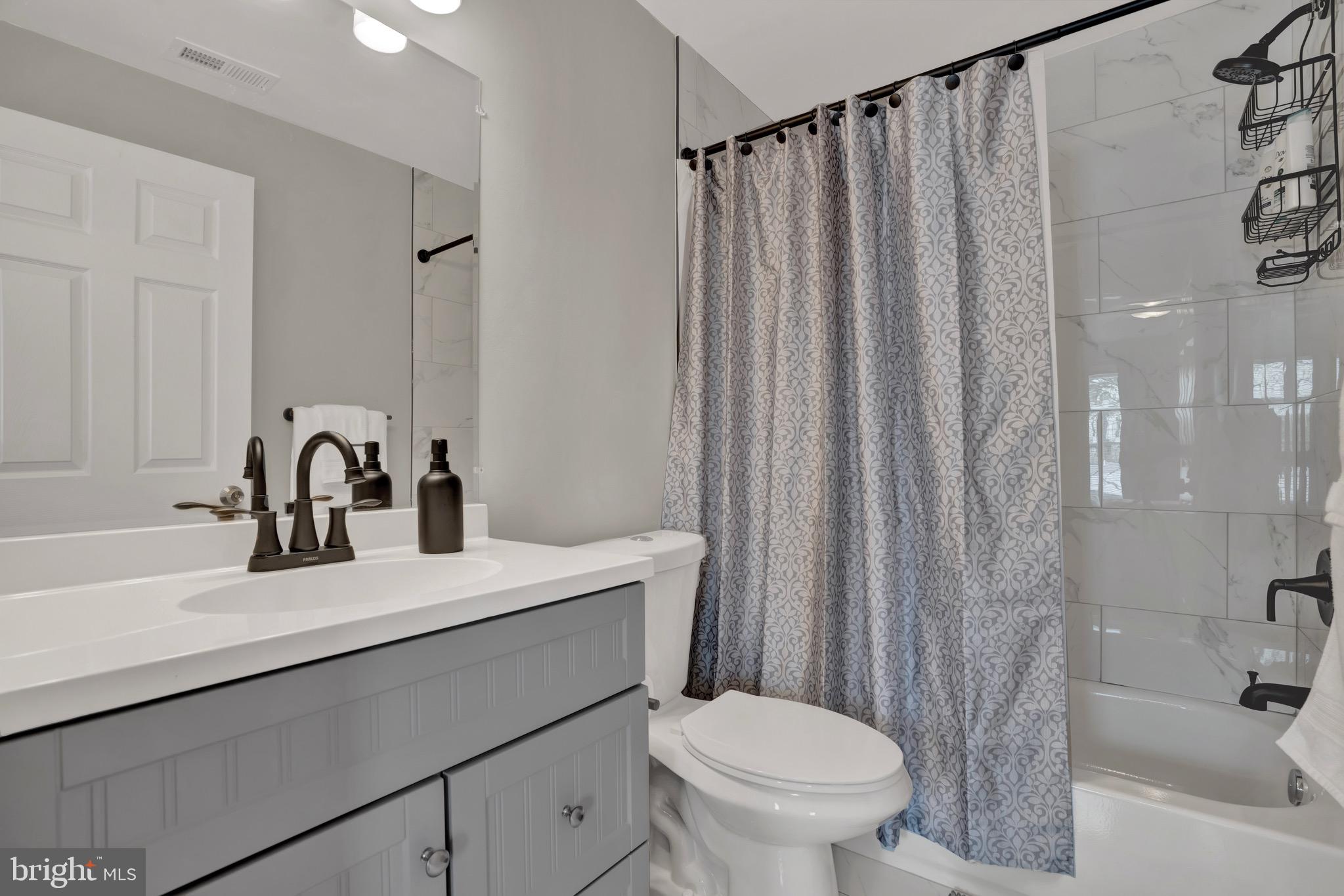 2111 East Chase Street Baltimore, MD 21213 - Photo 18 of 19 a bathroom with a sink a toilet and a tub