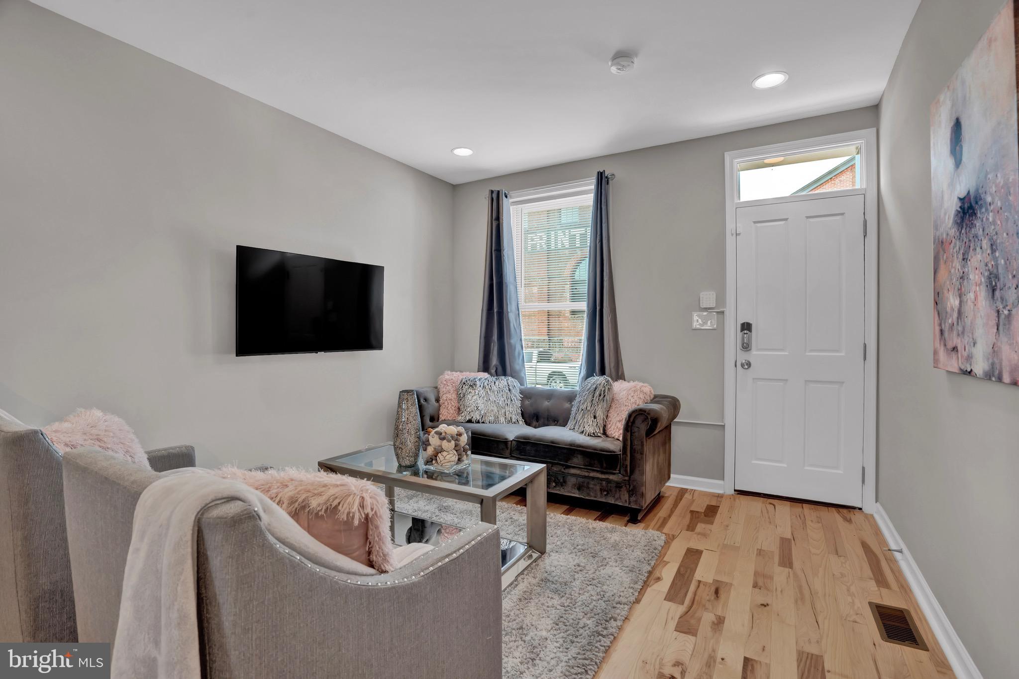 2111 East Chase Street Baltimore, MD 21213 - Photo 3 of 19 a living room with furniture and a flat screen tv