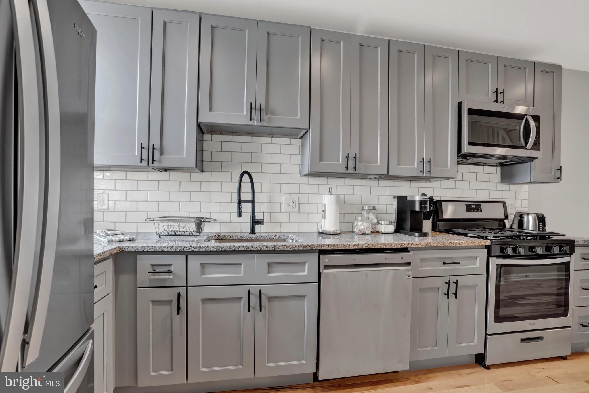 2111 East Chase Street Baltimore, MD 21213 - Photo 9 of 19 a kitchen with white cabinets and appliances