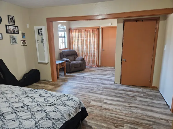 a bedroom with a bed and wooden floor