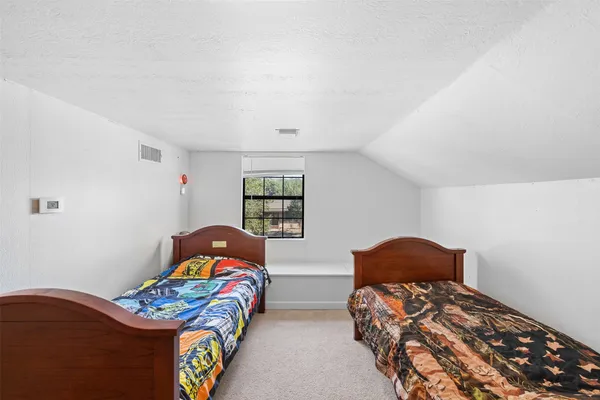 a bedroom with two beds and a window