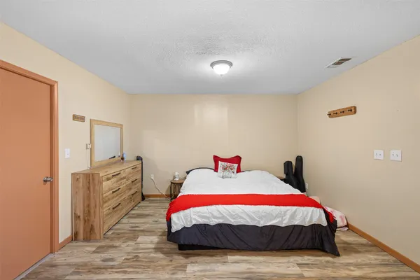 a spacious bedroom with a bed and a dresser