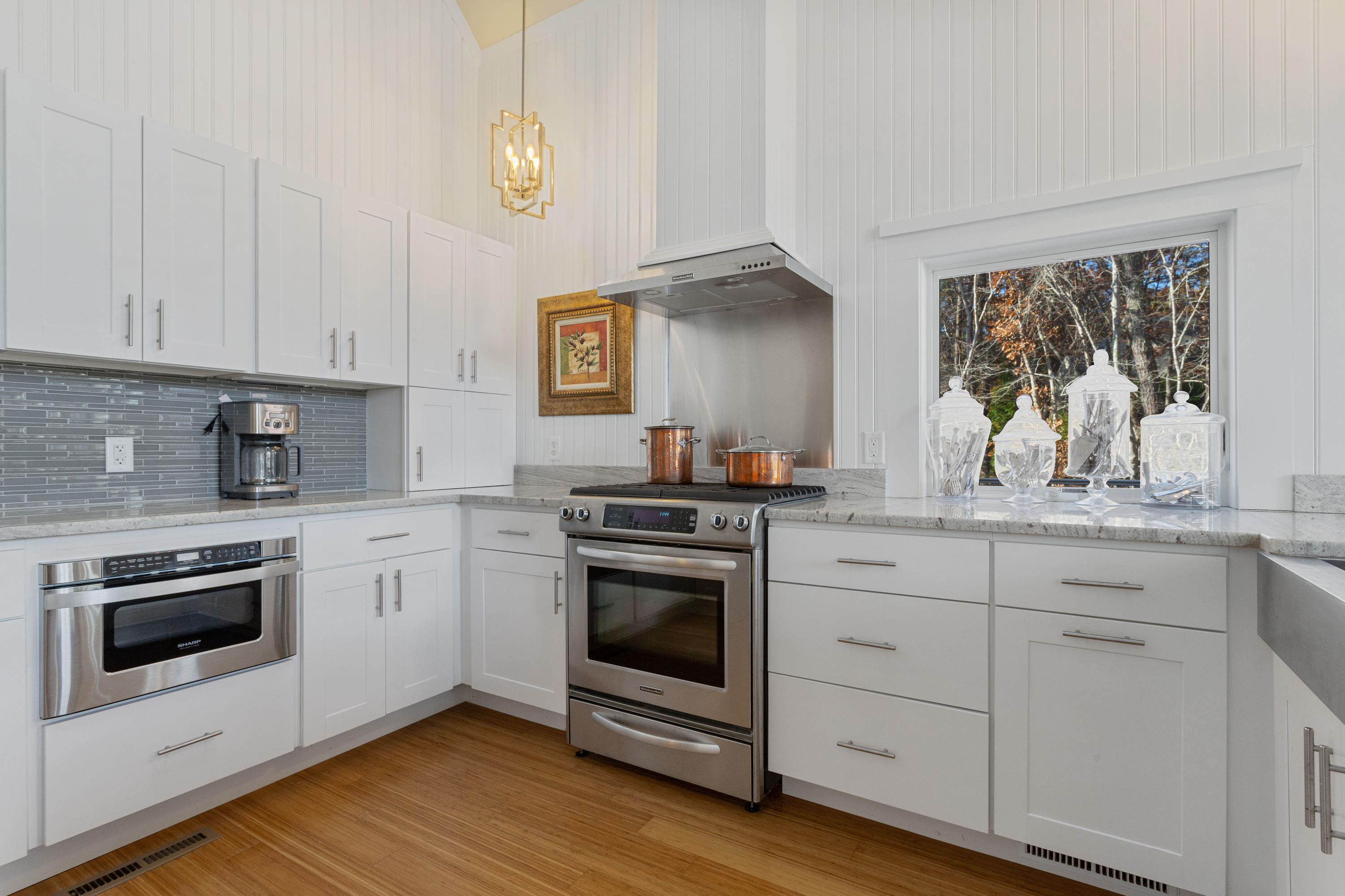 205 Uncle Percy's Road Mashpee, MA 02649 - Photo 15 of 54 a kitchen with granite countertop white cabinets stainless steel appliances and wooden floor