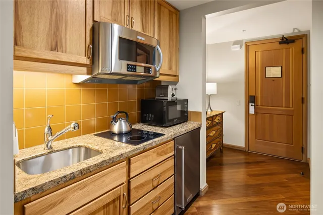 a kitchen with stainless steel appliances granite countertop a sink a stove and refrigerator