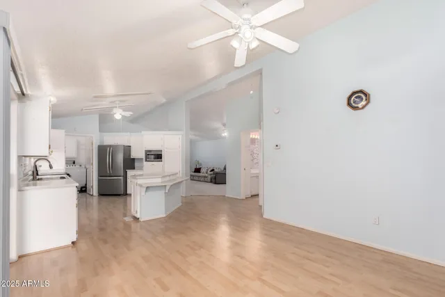 a view of a kitchen with wooden floor and stainless steel appliances
