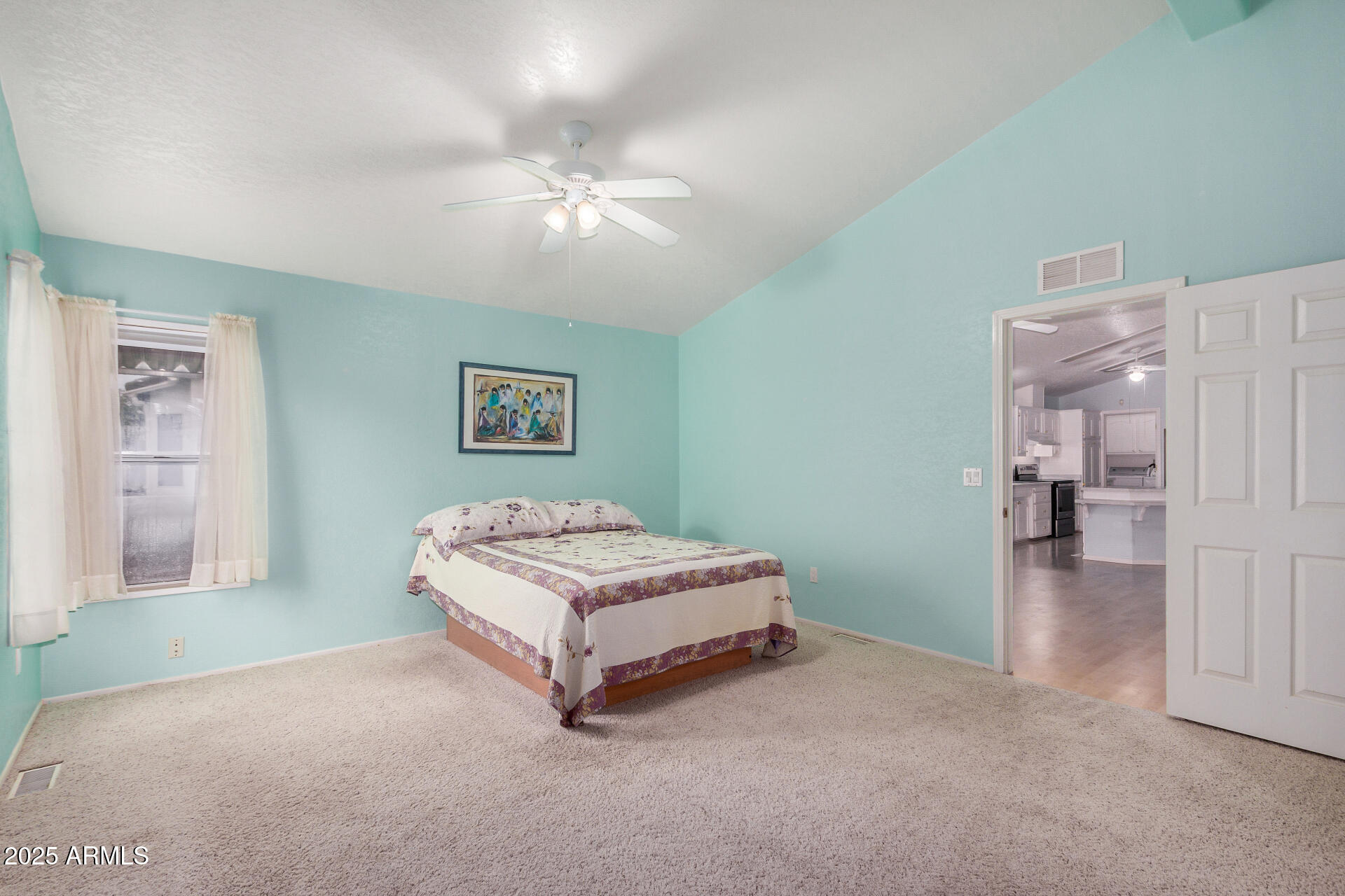 2101 South Meridian Road, Unit 27 Apache Junction, AZ 85120 - Photo 16 of 29 a spacious bedroom with a bed and a chandelier