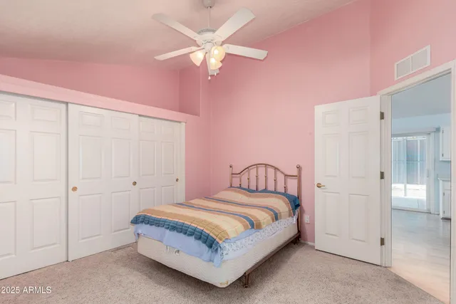 a spacious bedroom with a bed and a chandelier
