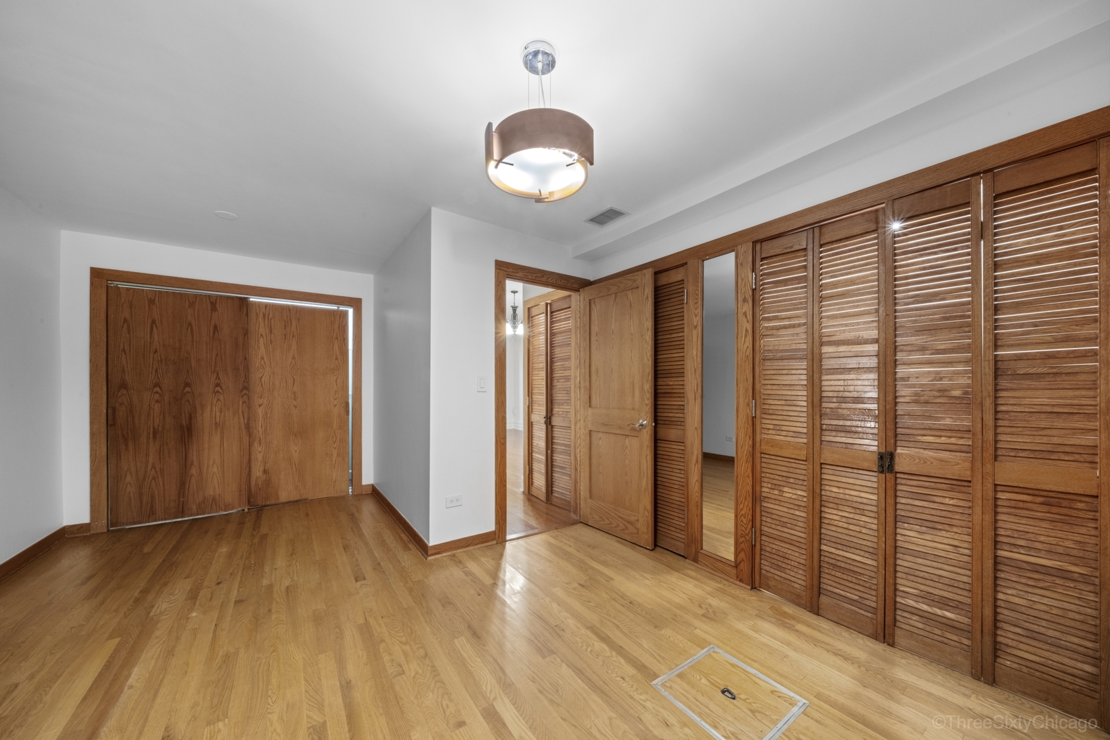 1526 North LaSalle Drive, Unit 1E Chicago, IL 60610 - Photo 12 of 17 an empty room with wooden floor and windows