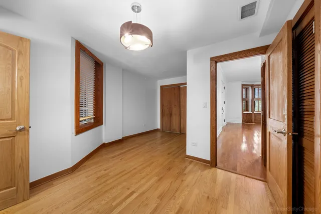 wooden floor in a hall with an entryway and a window