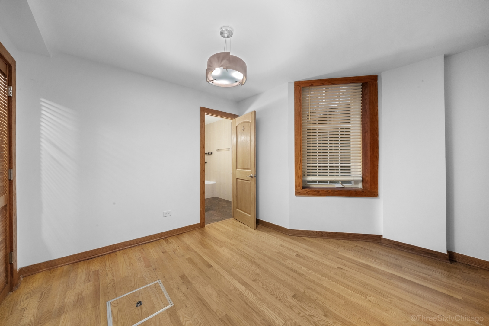 1526 North LaSalle Drive, Unit 1E Chicago, IL 60610 - Photo 14 of 17 an empty room with wooden floor and windows