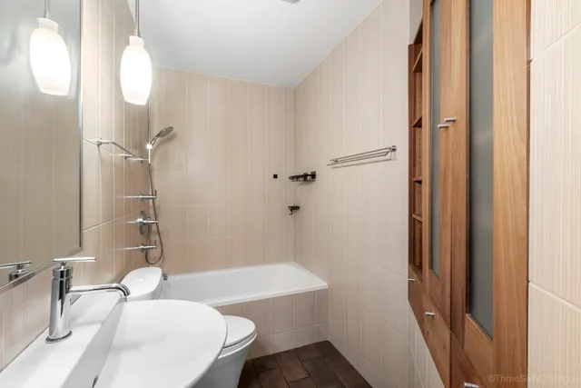 a bathroom with a sink a toilet and shower