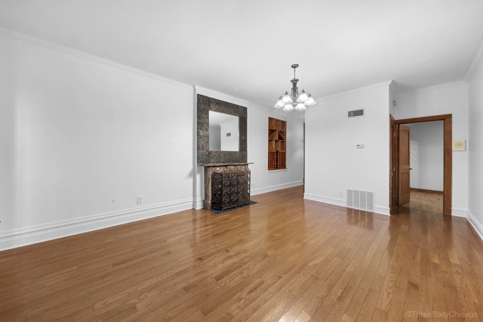 1526 North LaSalle Drive, Unit 1E Chicago, IL 60610 - Photo 3 of 17 a view of an empty room with wooden floor and a chandelier