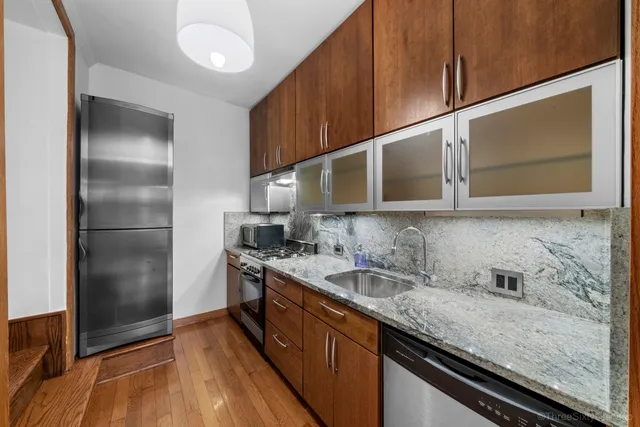 a kitchen with stainless steel appliances granite countertop a sink stove and refrigerator