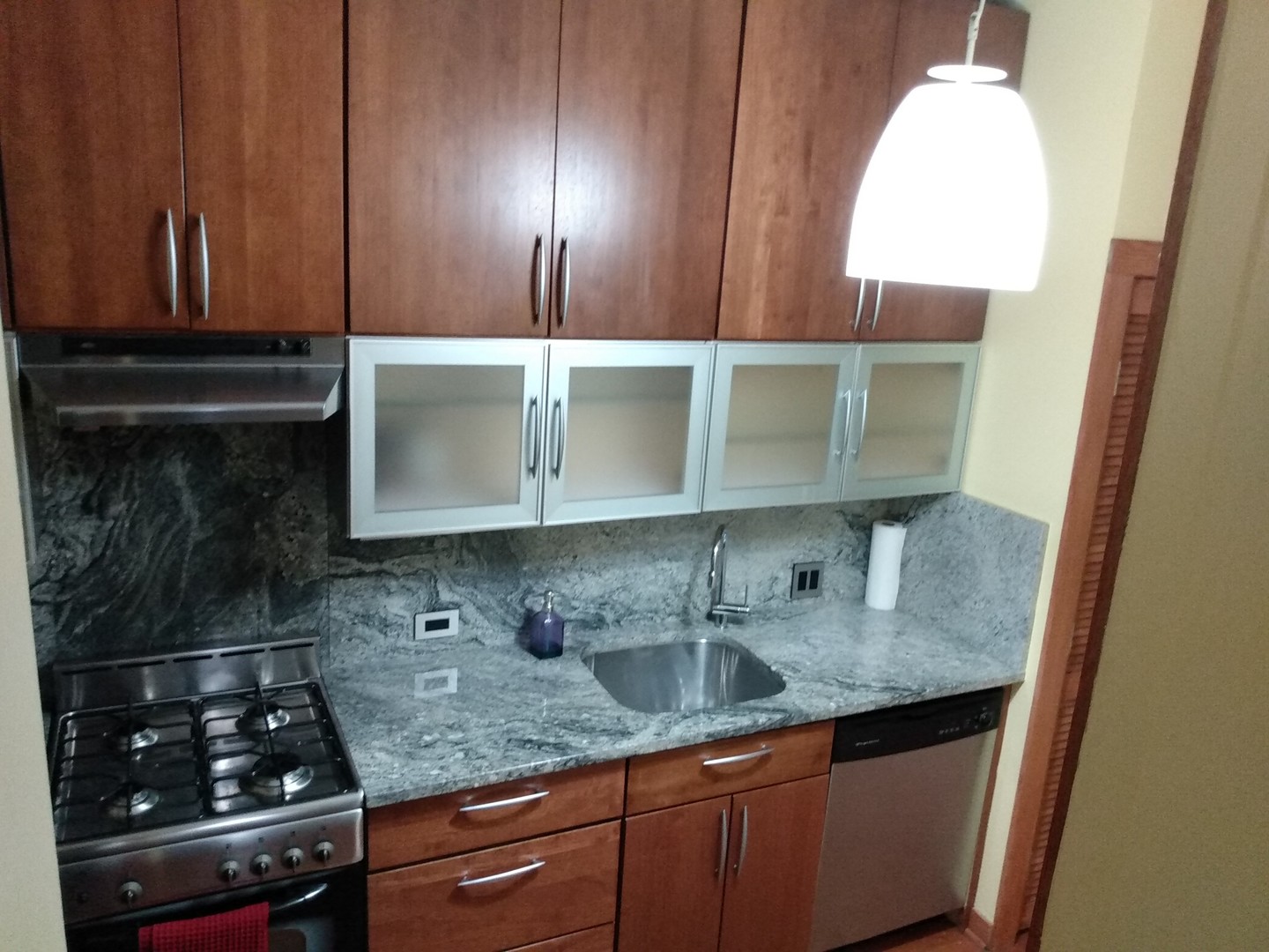 1526 North LaSalle Drive, Unit 1E Chicago, IL 60610 - Photo 8 of 17 a kitchen with granite countertop a sink a stove and cabinets
