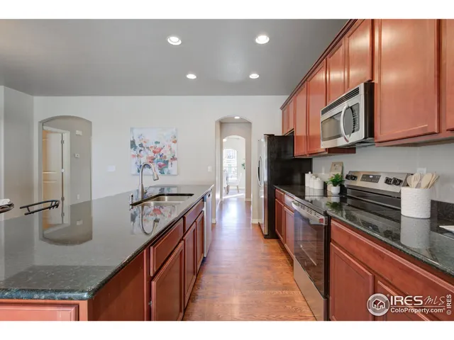 a kitchen with stainless steel appliances granite countertop a stove a refrigerator a sink and dishwasher