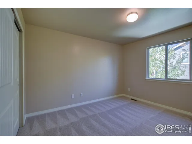 a bathroom with a granite countertop sink toilet a mirror and a window