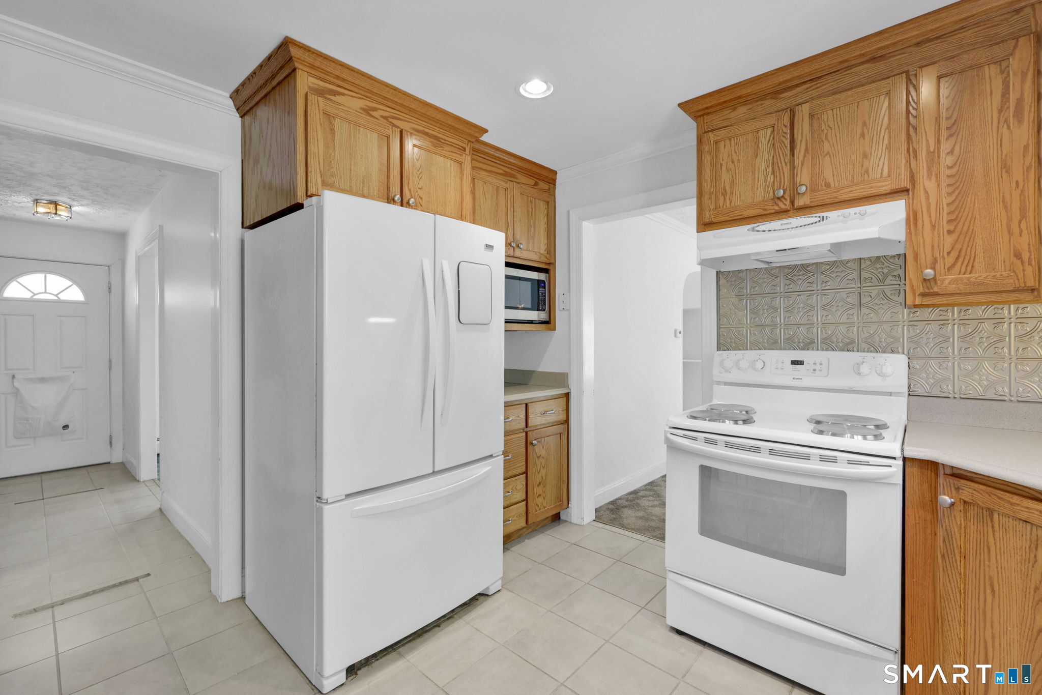53 Alexander Street Manchester, CT 06040 - Photo 8 of 35 a kitchen with a refrigerator a stove top oven and cabinets