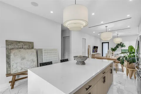 a kitchen with a table chairs and white cabinets