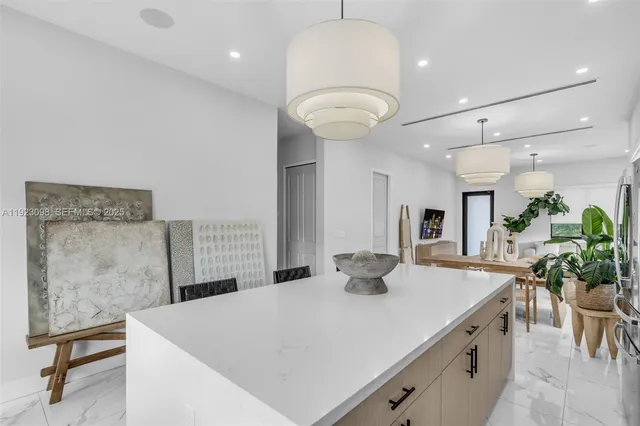 a kitchen with a table chairs and white cabinets