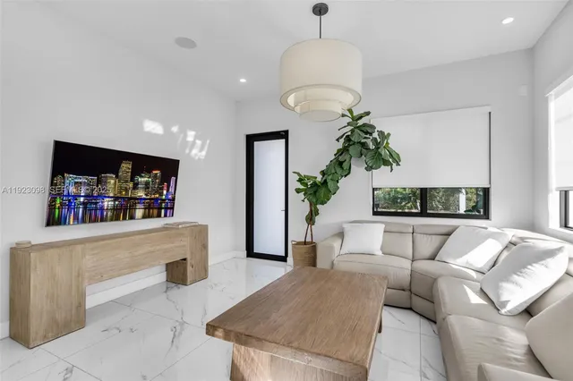 a living room with furniture a chandelier and a flat screen tv