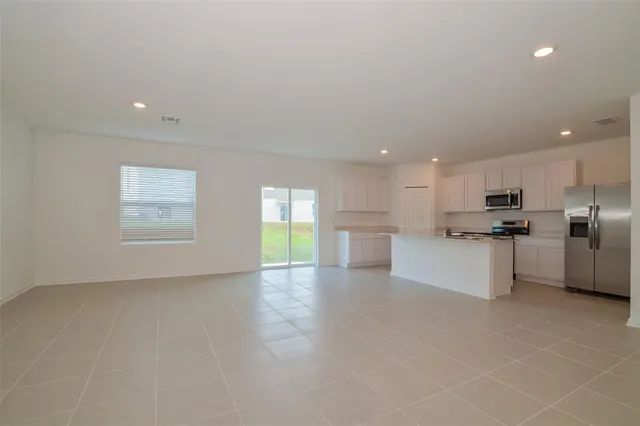 a view of kitchen with windows and white cabinets