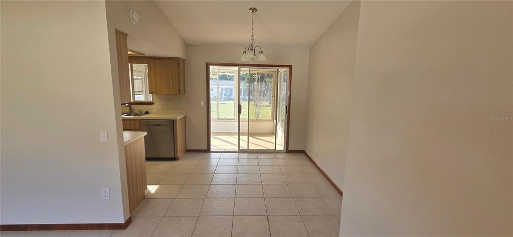 8246 Southwest 105th Place Ocala, FL 34481 - Photo 2 of 14 a hallway with sliding door and chandelier