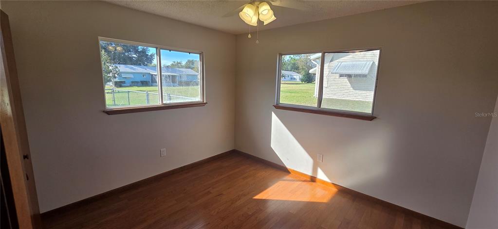8246 Southwest 105th Place Ocala, FL 34481 - Photo 10 of 14 an empty room with wooden floor and windows