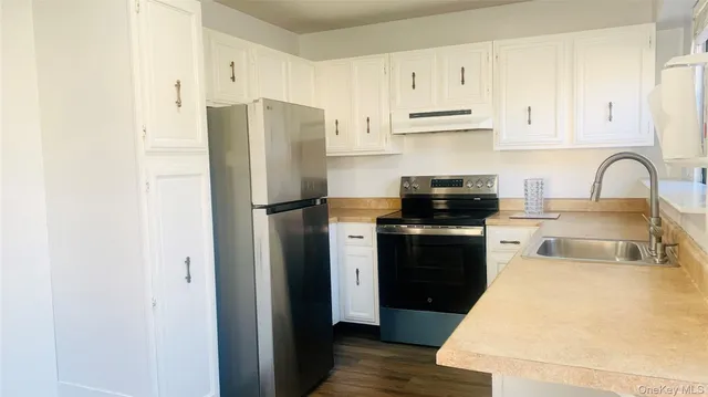 a kitchen with a refrigerator stove and white cabinets