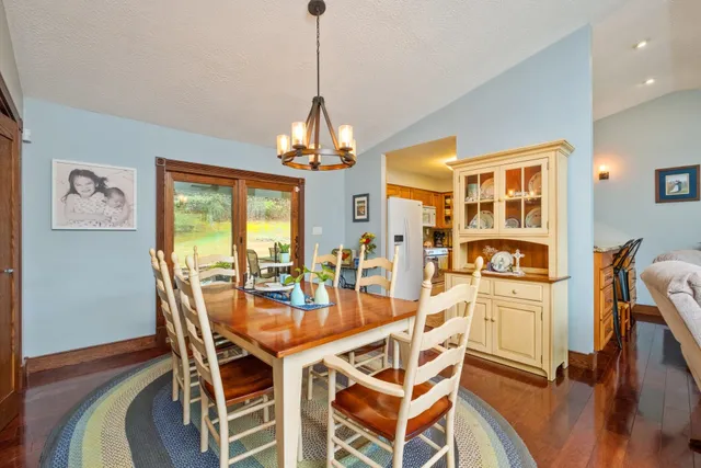 a dining room with furniture a chandelier and wooden floor