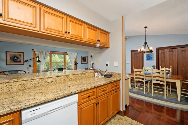 a view of a kitchen with granite countertop a sink and cabinets