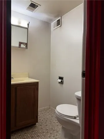 a bathroom with a toilet a sink and mirror