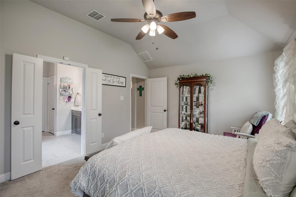 211 Rees Avenue Godley, TX 76044 - Photo 11 of 18 a bedroom with a large bed and a chandelier