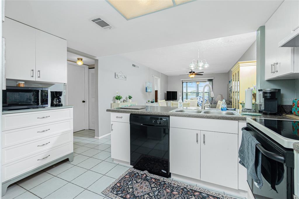 25225 Rampart Boulevard, Unit 1701 Punta Gorda, FL 33983 - Photo 6 of 21 a kitchen with granite countertop white cabinets and stainless steel appliances