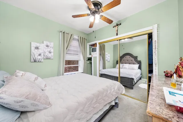 a bedroom with a bed mirror and a window