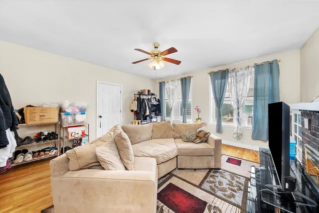 a living room with furniture a flat screen tv and a floor to ceiling window