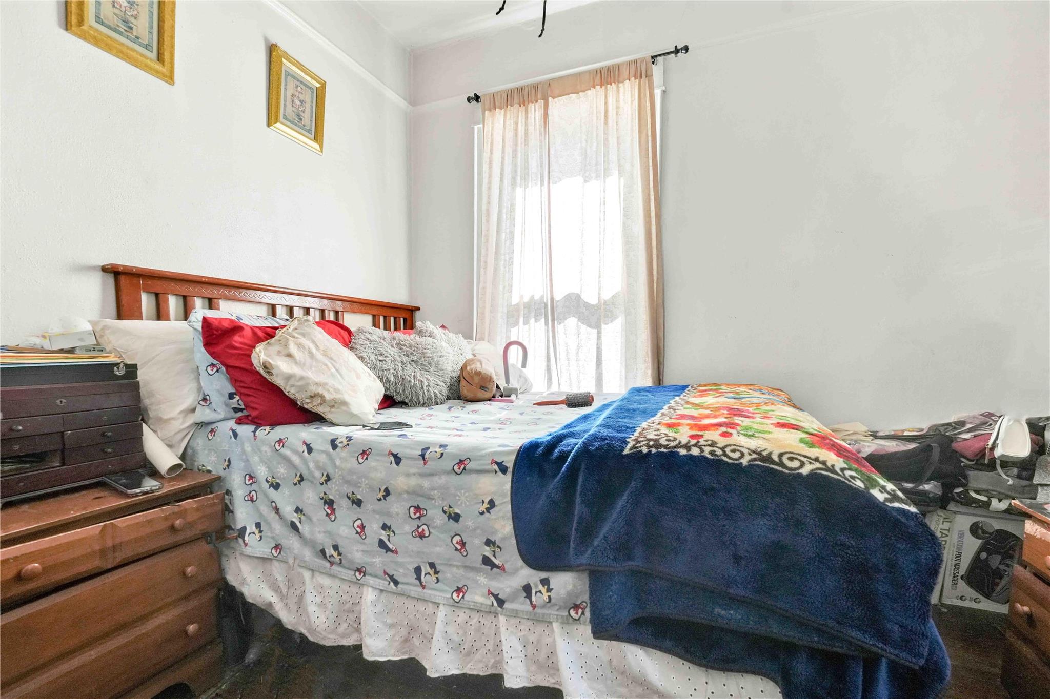 9908 35th Avenue Queens, NY 11368 - Photo 14 of 22 a bedroom with a bed and a window