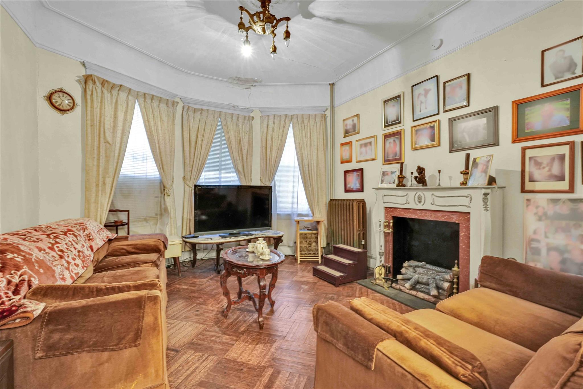 9908 35th Avenue Queens, NY 11368 - Photo 3 of 22 a living room with furniture a fireplace and a flat screen tv