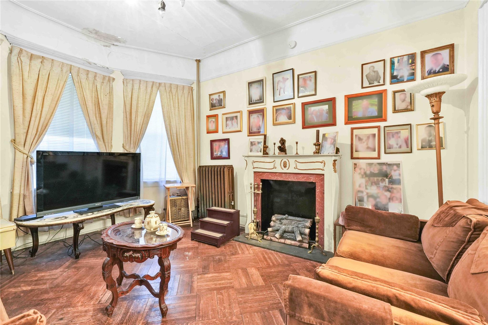 9908 35th Avenue Queens, NY 11368 - Photo 4 of 22 a living room with fireplace furniture and a flat screen tv