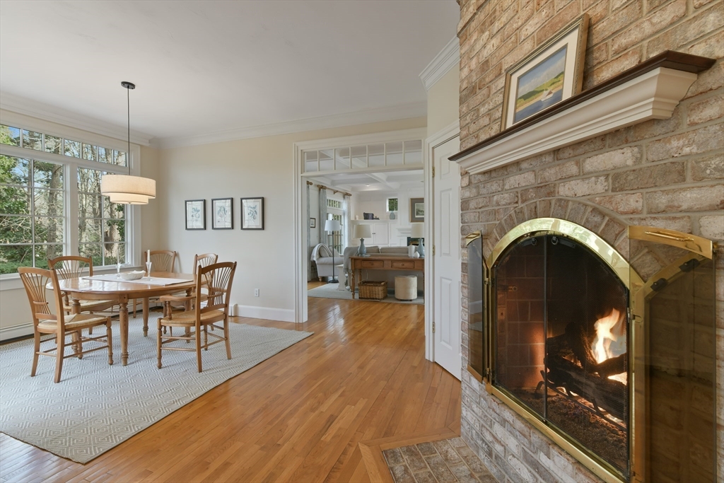 11 Olmsted Drive Hingham, MA 02043 - Photo 12 of 36 a living room with furniture a fireplace and a dining table with wooden floor