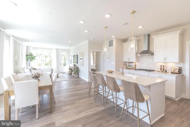 a large kitchen with dining table chairs and wooden floor