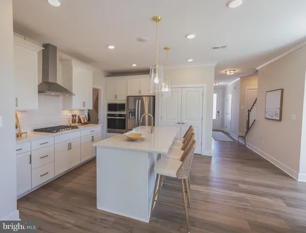 a large kitchen with kitchen island a island a sink a stove and a refrigerator