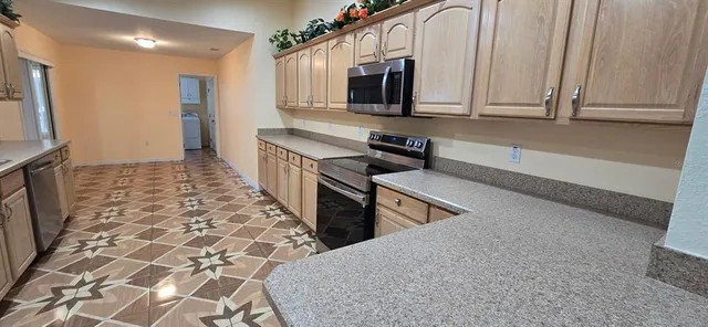 a kitchen with stainless steel appliances a stove microwave and sink
