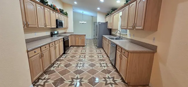 a kitchen with stainless steel appliances a sink and cabinets