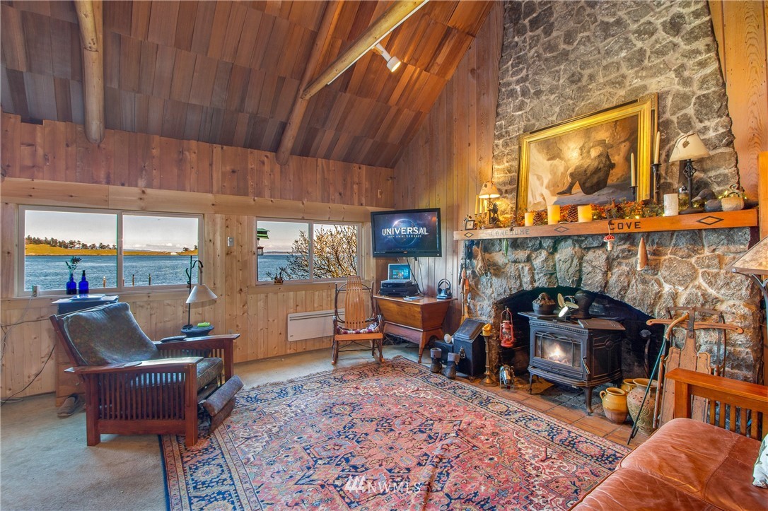 416 Lonesome Cove Road Friday Harbor, WA 98250 - Photo 15 of 40 a living room with furniture a fireplace and a floor to ceiling window