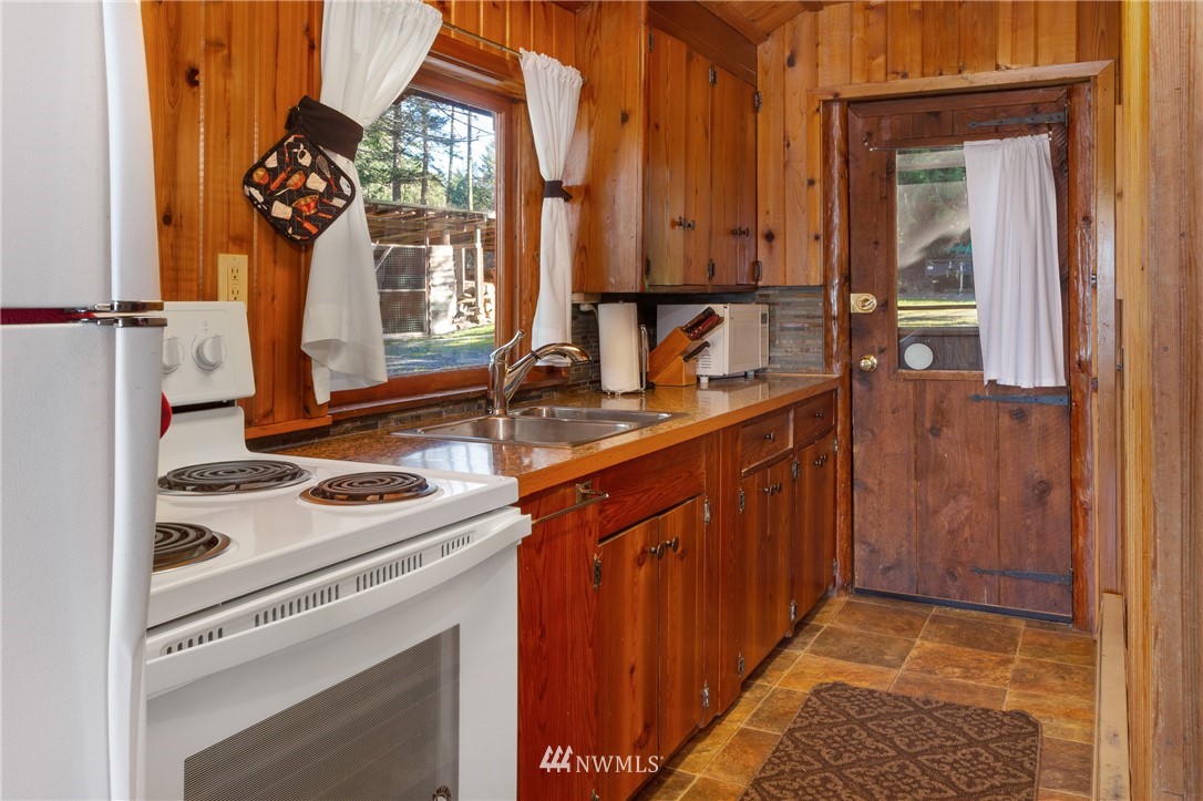 416 Lonesome Cove Road Friday Harbor, WA 98250 - Photo 37 of 40 a kitchen with a sink stove and cabinets