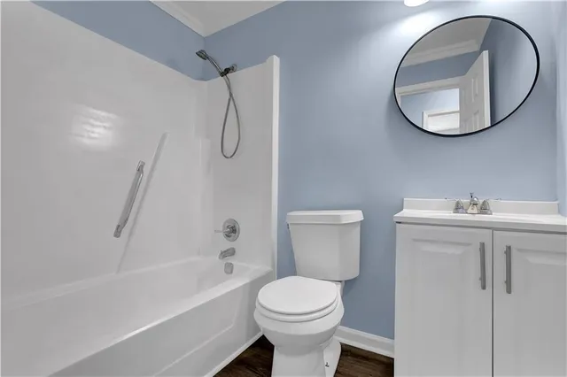 a bathroom with a toilet sink vanity and bathtub