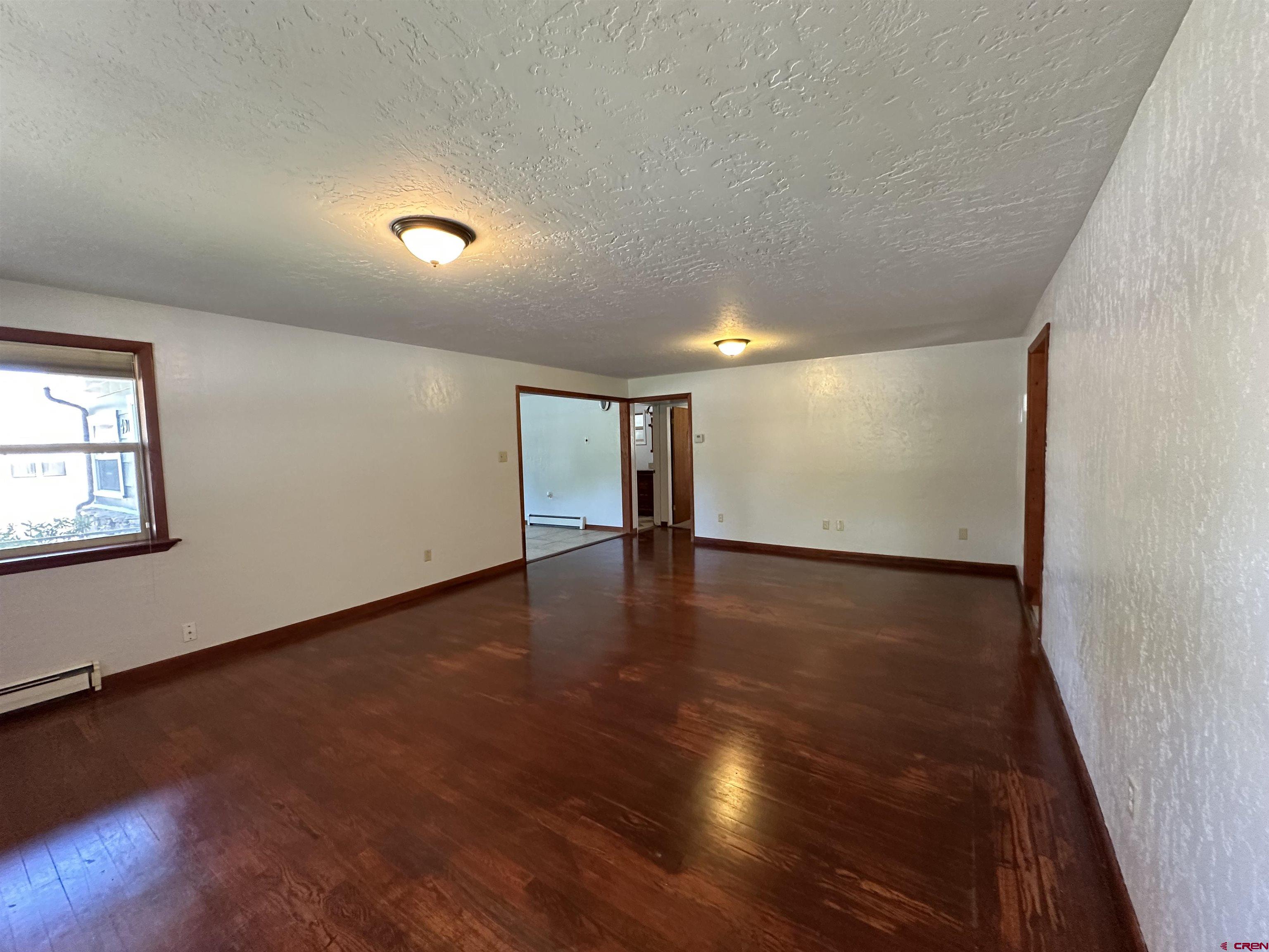 490 West Main Street Cedaredge, CO 81413 - Photo 17 of 31 an empty room with wooden floor and windows